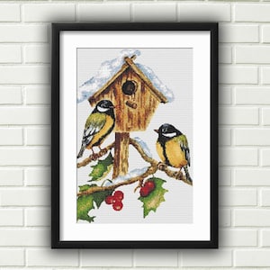 以下が含まれることがあります： 赤い実のついた枝に、黄色と黒の鳥が2羽とまっている。鳥の巣箱は木製の屋根に雪が積もっている。