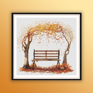 May include: A wooden bench sits under a tree with orange and yellow leaves. The leaves are falling from the tree and are scattered on the ground around the bench.