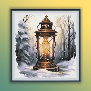 May include: A vintage lantern with a warm glow illuminates a snowy woodland scene. The lantern is made of metal and has a glass window. The woodland is covered in snow and the trees are bare.