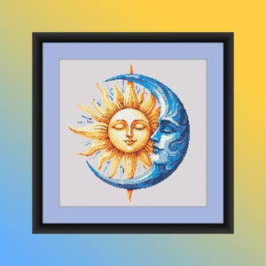 Può includere: Un'opera d'arte a punto croce incorniciata con un design celeste. L'immagine raffigura un sole sorridente con gli occhi chiusi e una luna crescente blu con un volto. Il sole è giallo e la luna è blu, su uno sfondo azzurro.