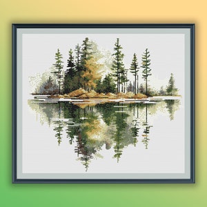 Op de afbeelding: Een kruissteekpatroon dat een serene scène van een meer met een klein eiland bedekt met bomen die in het water worden weerspiegeld, afbeeldt. De bomen zijn een mix van groen en bruin, en het water is lichtblauw. De lucht is zacht wit.