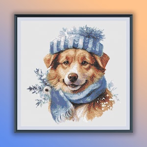 Puede incluir: Un perro marrón y blanco con un gorro a rayas azul y blanco con un pompón blanco y una bufanda azul. El perro mira a la cámara y tiene una expresión feliz.