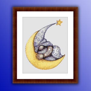 May include: A framed cross-stitch artwork depicts a sleeping figure in a nightcap and pajamas, nestled on a crescent moon. The moon is yellow, and the figure's hat and pajamas are blue with white stars. A gold star hangs above.