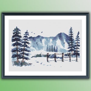 May include: A cross-stitch pattern depicting a winter scene with a snowy mountain range, a small lake, and three pine trees in the foreground. The trees are a dark blue colour, and the mountains are a light blue colour. The lake is a light blue colour, and the snow is a white colour.