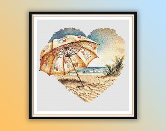 May include: A heart-shaped cross-stitch pattern depicting a beach scene with a colourful beach umbrella, sand, and ocean waves.