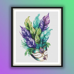 May include: A framed cross-stitch artwork featuring a Venetian mask with a colorful feather headdress. The mask is teal and gold, with purple, green, and teal feathers. The artwork is framed in a black frame.