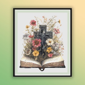 May include: A black cross with a floral arrangement of pink, white, and yellow flowers on top of an open book. The book is brown with gold accents.