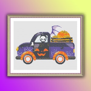 Op de afbeelding: Kruissteekkunst van een paarse Halloween-truck met een pompoengezicht en oranje wielen. De laadbak van de truck is gevuld met pompoenen en een spook. Een skelet zit op de bestuurdersstoel. Het kunstwerk is ingelijst.