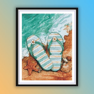 Op de afbeelding: Een paar blauwe en witte gestreepte slippers met een bloemetjespatroon op de band, liggend op een zandstrand met een zeester en schelpen.