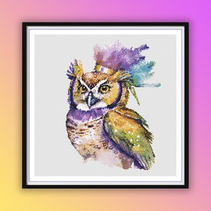 Könnte beinhalten: Eine farbenfrohe Eule mit einem violetten, blauen und goldenen Federkopfschmuck. Die Eule ist in Aquarelltechnik auf weißem Hintergrund dargestellt.
