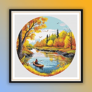 May include: A round cross-stitch pattern depicting a tranquil autumn scene with a river, trees with yellow and orange leaves, and a person in a boat.