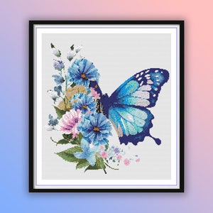 Può includere: Una farfalla blu con macchie bianche e nere è posata su un gruppo di fiori blu e rosa. I fiori sono circondati da foglie verdi e piccoli fiori bianchi.