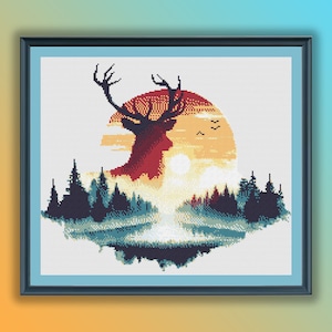Op de afbeelding: Een kruissteekpatroon met een silhouet van een hert dat in een bos staat met een zonsondergang erachter. Het hert is rood, oranje en geel, en het bos is groen en blauw.