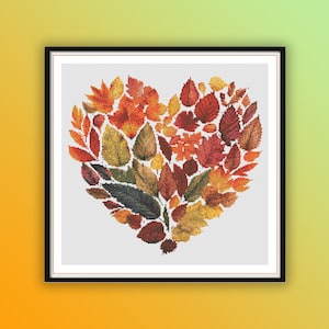 Puede incluir: Un diseño en forma de corazón hecho de varias hojas de otoño en tonos de rojo, naranja, amarillo y verde. Las hojas están dispuestas en un patrón que se asemeja a un corazón.