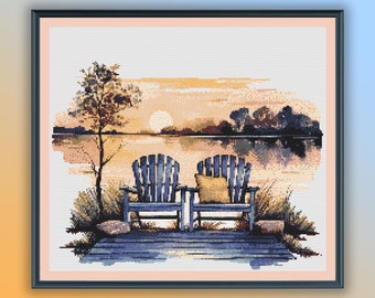 May include: Two blue wooden chairs with a yellow cushion on the right chair, sitting on a wooden jetty overlooking a lake at sunset. The lake is calm and reflects the orange and pink sky.