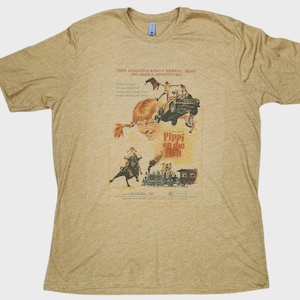 Pode incluir: Uma camiseta bege de gola redonda com um design de cartaz de filme vintage. O cartaz retrata Pippi Meialonga com o texto "Pippi on the Run" e outro texto. A camisa é feita de um material macio.