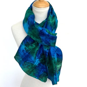 Hand-woven, hand-painted pure silk scarf in vivid blues and emerald green. Painted using the water-effect technique. A generous 72&quot; long.