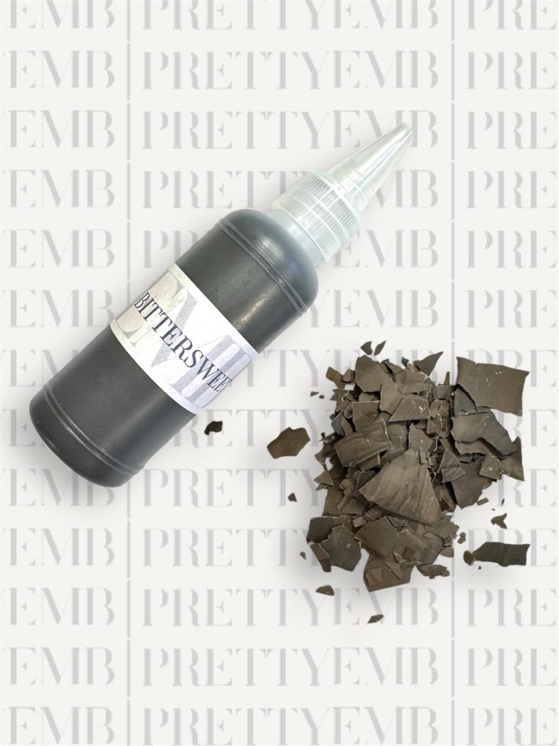 May include: A small bottle of black paint with a white label that says "Bittersweet". The bottle has a dropper top and is next to a pile of black paint chips.