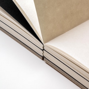 Close-up of the basenotes 2333 sketchbook showing section dividers, black inserts, and precise thread binding.