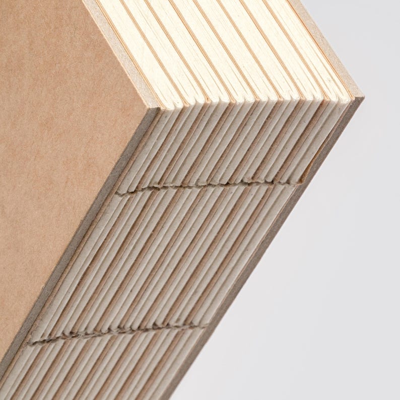 Peut inclure: Gros plan sur une pile de carnets vierges avec une couverture marron clair et des pages cr&egrave;me. Les pages sont solidement reli&eacute;es, cr&eacute;ant un bord textur&eacute;. Les carnets sont inclin&eacute;s, r&eacute;v&eacute;lant la construction en couches.
