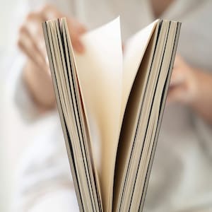 Close-up of pages being turned inside the basenotes 2333 sketchbook showing lay-flat design and textured sheets.