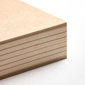 May include: Close-up of a stack of unfinished plywood sheets. The edges reveal the layered construction of the wood, with visible grain patterns. The wood has a light brown color and is set against a white background.