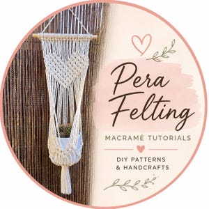 May include: A macrame plant hanger with a heart design, holding a small potted cactus. The off-white cotton hanger is suspended from a wooden dowel. The image includes the text "Pera Felting" and "Macrame Tutorials".