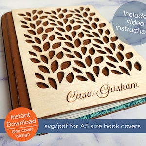 May include: A wooden book cover with a cut-out design of leaves and the name "Casa Grisham" engraved on the front. The cover is brown and has a light wood finish. The cover is for an A5 size book. The image includes the text "svg/pdf for A5 size book covers".