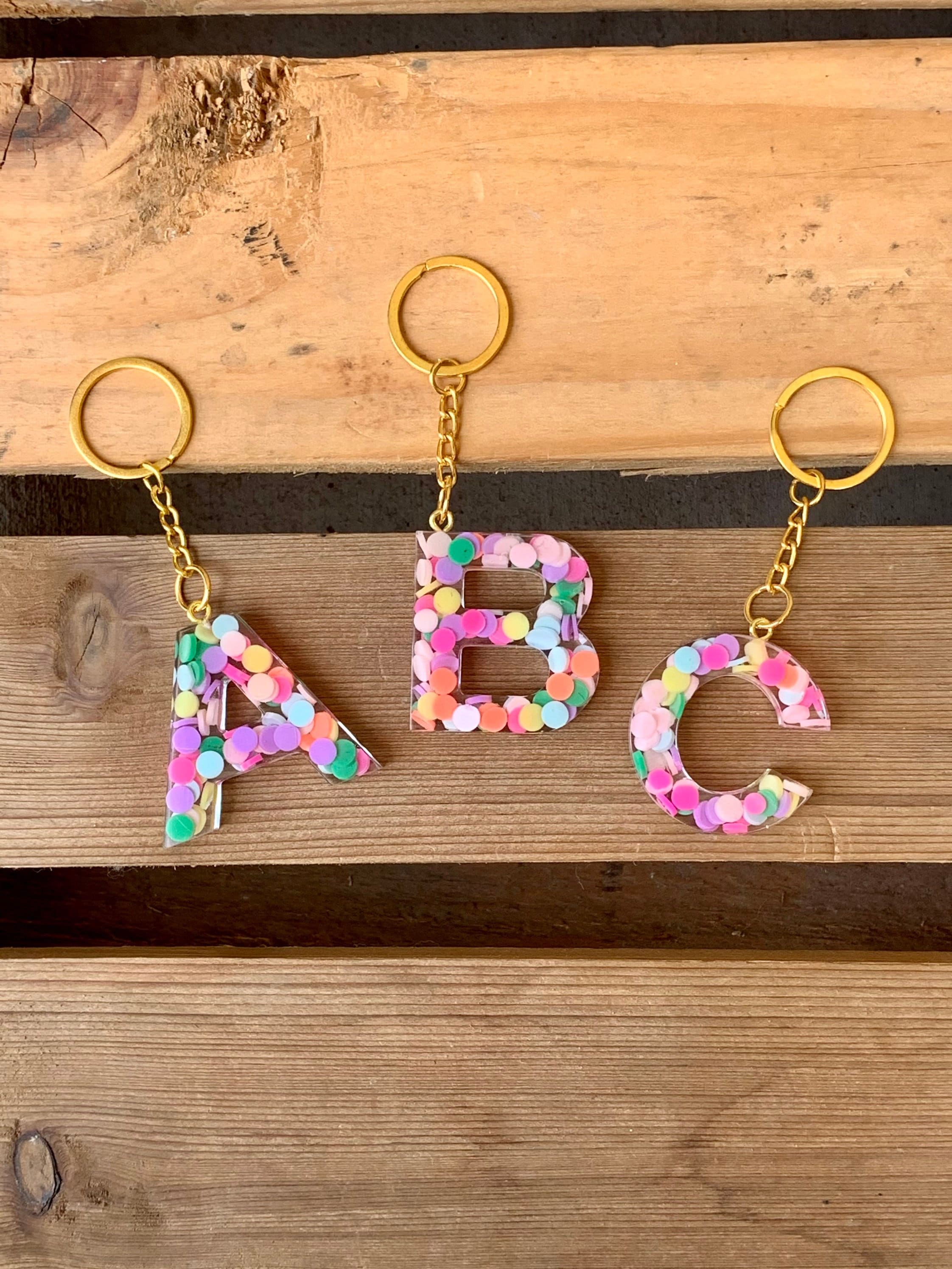 Crafty Angel Art F - Letter - Initial Resin Keychain Translucent Letter F with Sea Shells Inside It and Purple Party Glitter on The Front with A Beaded Charm and A Paw