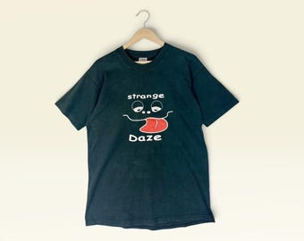 Camiseta Vintage Strange Daze dos anos 90 com estampa – Arte psicodélica de desenho animado / Olhos tontos e rosto com a língua para fora / Preta FOTL – Fabricada nos EUA – Tamanho G