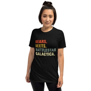 Pu&ograve; includere: Maglietta nera con una grafica in stile vintage che recita "BEARS. BEETS. BATTLESTAR GALACTICA."