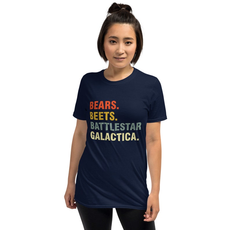 Pu&ograve; includere: Una t-shirt blu navy con una grafica in stile vintage che recita "BEARS. BEETS. BATTLESTAR GALACTICA."