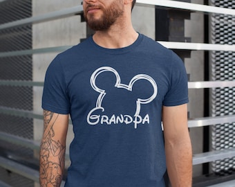 May include: A navy blue t-shirt with a white outline of Mickey Mouse ears and the word "Grandpa" underneath.