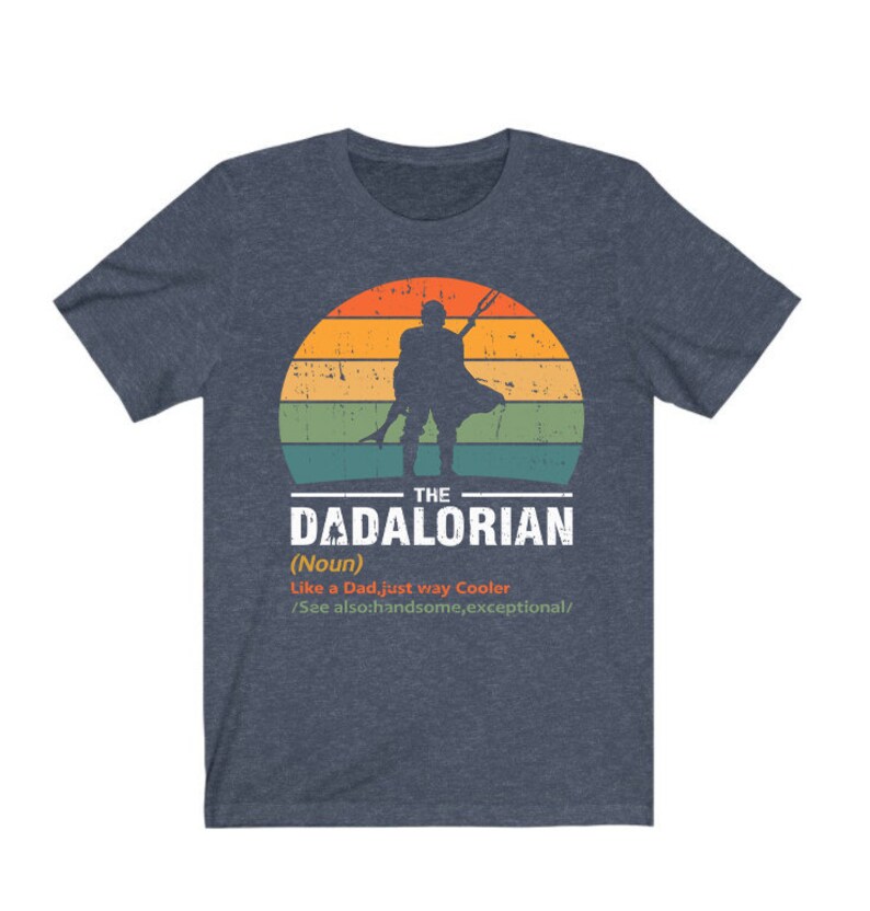 May include: Dark blue t-shirt with a graphic of a figure holding a weapon against a sunset. The text reads "THE DADALORIAN (Noun) Like a Dad, just way Cooler /See also: handsome, exceptional/."