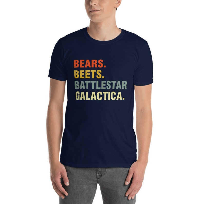 Pu&ograve; includere: Una t-shirt blu navy con una grafica in stile vintage che recita "BEARS. BEETS. BATTLESTAR GALACTICA."