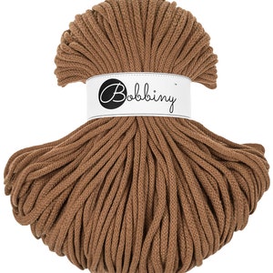 May include: A spool of brown cotton cord, approximately 100 meters long, with the brand name "Bobbiny" printed on a white label.