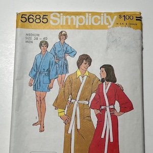 May include: Simplicity sewing pattern number 5685 for a robe. The pattern includes three different robe designs: a blue robe, a brown robe with yellow trim, and a red robe. The pattern is labeled "Jiffy easy cut-easy sew" and includes five main pattern pieces.