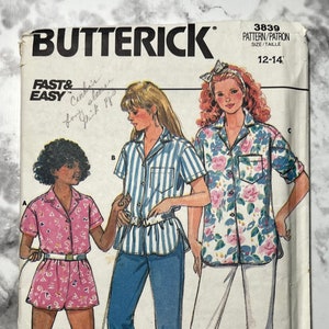 May include: A sewing pattern for a shirt with three different designs. The pattern is for sizes 12-14. The designs include a striped shirt, a floral shirt, and a pink and white patterned shirt.