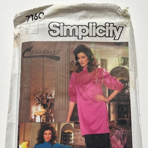May include: Simplicity sewing pattern number 7160 for a dress. The pattern includes two different styles: a pink dress with a high neck and a blue dress with a high neck. The pattern is for sizes Eur 42.