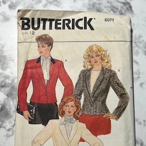 May include: A vintage sewing pattern for a blazer, featuring three different styles. The pattern is from Butterick and is size 12. The blazer styles are a red blazer with a white bow, a black and white patterned blazer, and a white blazer with a striped bow.