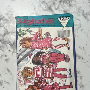 Puede incluir: Un patrón de costura para ropa de niños, con cuatro niñas que llevan diferentes atuendos. El patrón se llama "Busybodies" y el número es 4527. La talla es 4-5-6.