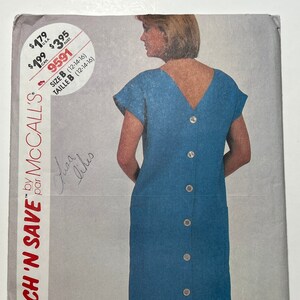 May include: A blue dress sewing pattern with a button-up back. The pattern is for sizes 12-14-16. The pattern is called "Stitch 'N Save" by McCall's.