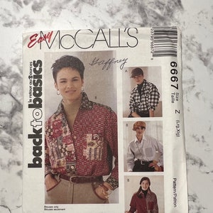 May include: McCall's Easy Back to Basics sewing pattern for a women's blouse. The pattern is for size Z (Large/Extra Large) and is called "Gaffrey". The pattern includes three different views of the blouse, one with a plaid fabric, one with a solid white fabric, and one with a patchwork fabric.