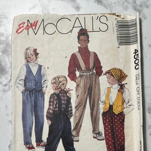 May include: A sewing pattern for children's overalls. The pattern includes three different styles of overalls: one with a vest, one with a plaid shirt, and one with a solid red shirt. The pattern is for sizes 7, 8, and 10. The pattern is from McCall's Easy.
