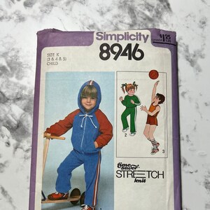 May include: Simplicity pattern 8946 for children's knit clothing. The pattern envelope features illustrations of children in tracksuits and athletic wear. The envelope is purple and white with the price $1.25.