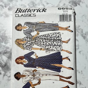 May include: A sewing pattern envelope for a dress with five different styles. The envelope is white with a blue and white striped design and the text "Butterick Classics 6698" printed on the front.