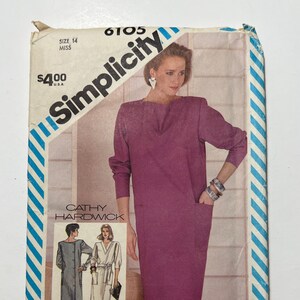 May include: Simplicity sewing pattern number 6105 for a dress. The pattern is for size 14 miss and costs $4.00. The pattern features a dress with long sleeves and a pocket. The pattern is by Cathy Hardwick.
