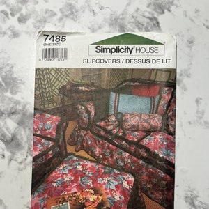 May include: Simplicity House sewing pattern number 7485 for slipcovers. The pattern shows a floral print with pink, blue, and green colors. The pattern includes instructions for making slipcovers for a bed and pillows.