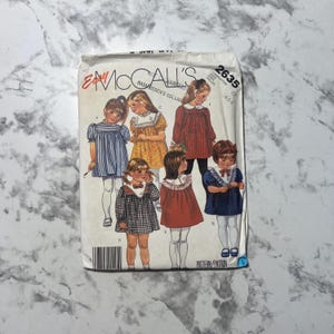 May include: Vintage McCall's sewing pattern packet featuring illustrations of little girls in dresses. The packet has the number 2635 and the brand name "McCall's" printed on it. The packet is slightly worn and has a barcode.