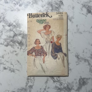 May include: Vintage sewing pattern for a blouse with a square neckline and long sleeves. The pattern is from Butterick and is number 5885. The pattern is for sizes 10-18.